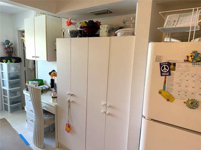 kitchen featuring light tile patterned floors, visible vents, and freestanding refrigerator