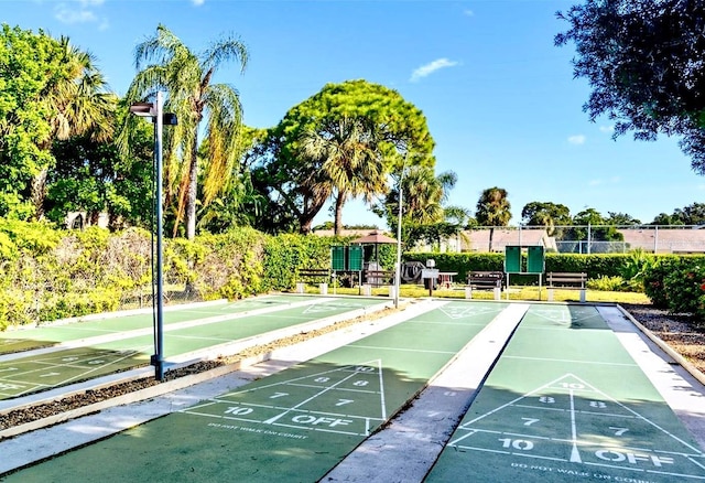 view of home's community featuring shuffleboard and fence