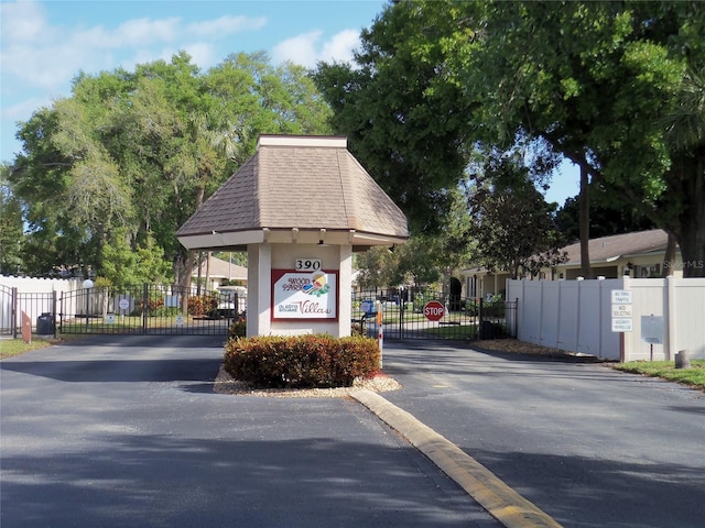 view of street with a gate, traffic signs, and a gated entry