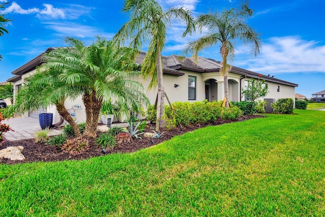 mediterranean / spanish house with a front lawn and stucco siding