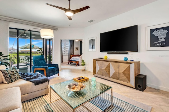 living room with baseboards, light tile patterned flooring, visible vents, and a ceiling fan