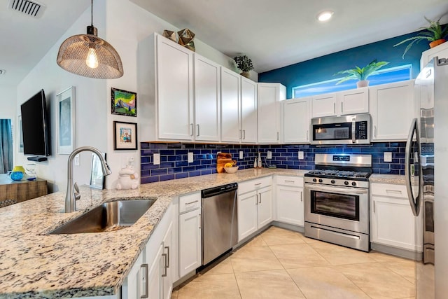 kitchen with visible vents, decorative backsplash, appliances with stainless steel finishes, a sink, and a peninsula