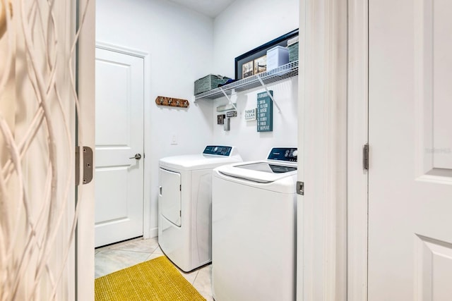 laundry area with light tile patterned floors, laundry area, and washer and clothes dryer