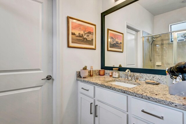 full bath with a stall shower and vanity