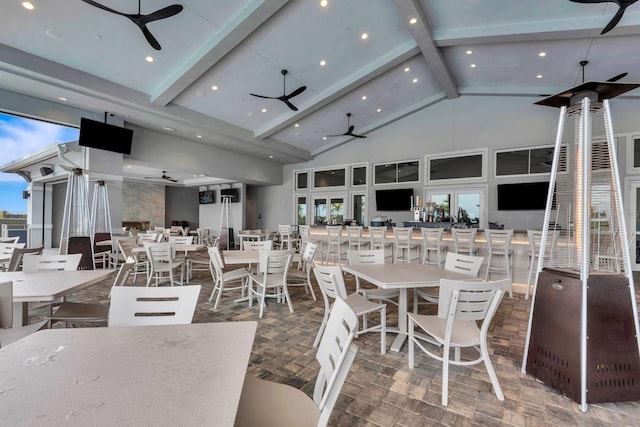 dining space with high vaulted ceiling, a wealth of natural light, beamed ceiling, and a ceiling fan