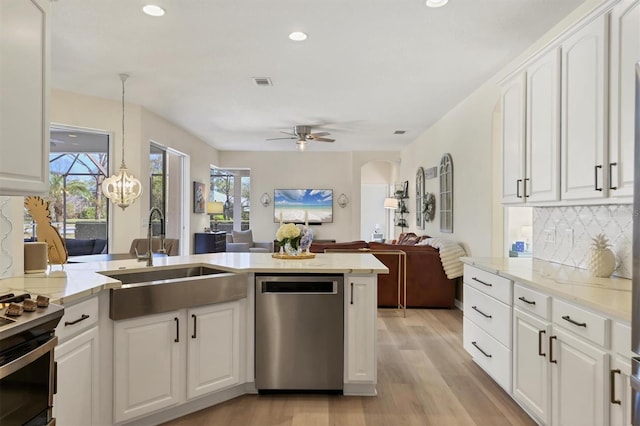 kitchen featuring stainless steel appliances, a sink, visible vents, open floor plan, and plenty of natural light