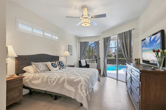 bedroom featuring access to exterior, a ceiling fan, and wood finished floors