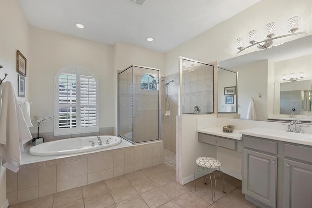 bathroom with tile patterned flooring, a walk in shower, a bath, and vanity