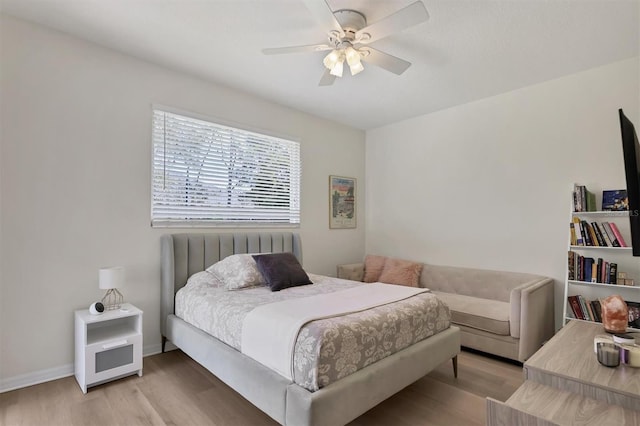 bedroom with ceiling fan, baseboards, and wood finished floors