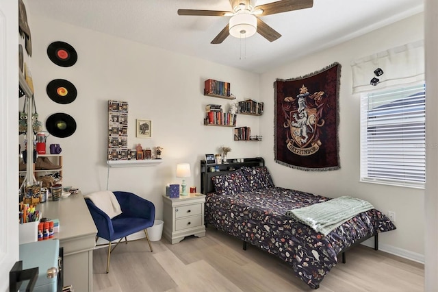 bedroom featuring ceiling fan, baseboards, and wood finished floors