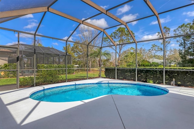 outdoor pool with glass enclosure and a patio area