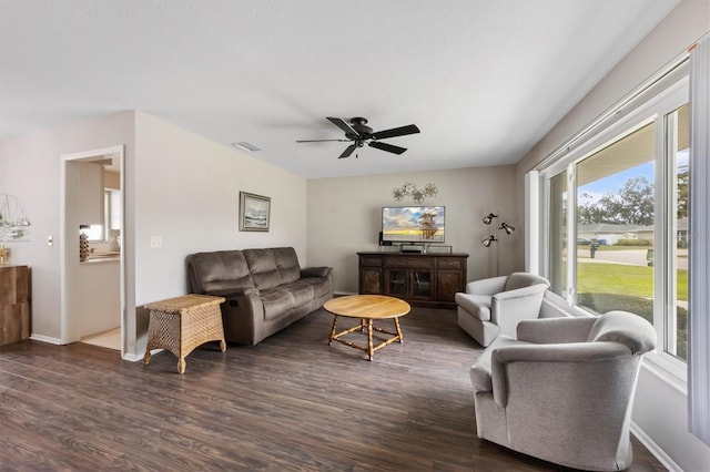 living area featuring a ceiling fan, dark wood-style flooring, visible vents, and baseboards