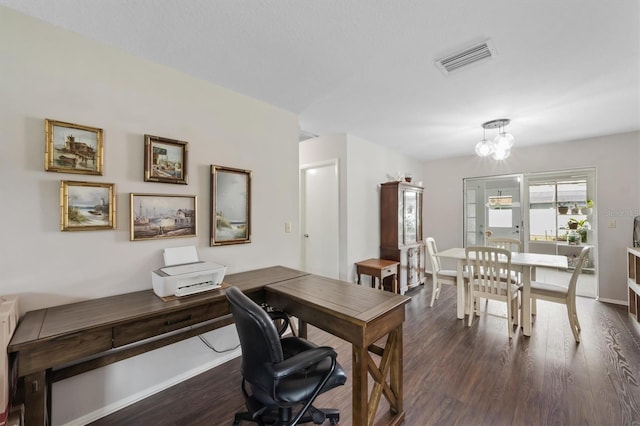 office area with dark wood-type flooring, visible vents, and baseboards