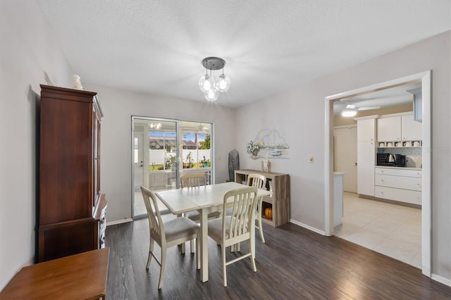 dining area with a notable chandelier, wood finished floors, and baseboards