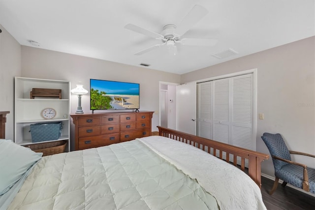 bedroom featuring a closet, wood finished floors, visible vents, and a ceiling fan