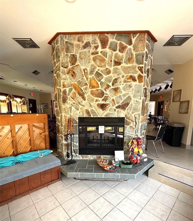 tiled living area with a fireplace and visible vents