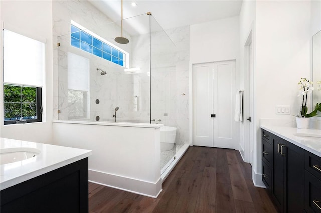 bathroom featuring wood finished floors, a healthy amount of sunlight, and a walk in shower