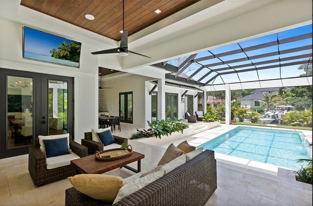 pool featuring a lanai, a ceiling fan, a patio, and french doors