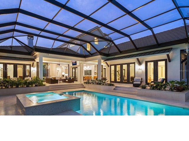 view of swimming pool featuring french doors, a pool with connected hot tub, outdoor lounge area, a patio area, and a lanai