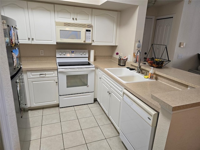 kitchen featuring white appliances, a peninsula, light countertops, a sink, and light tile patterned flooring