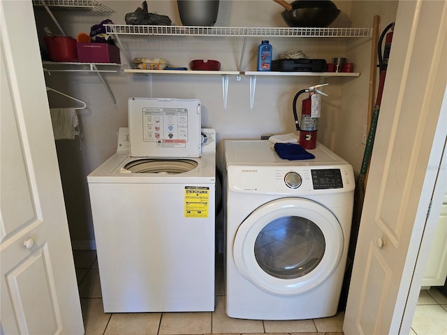 washroom featuring light tile patterned floors, laundry area, and independent washer and dryer