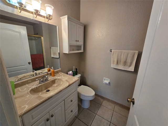 bathroom featuring toilet, vanity, baseboards, tile patterned floors, and an enclosed shower