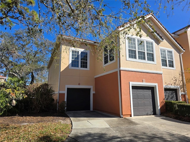 view of front facade featuring driveway, an attached garage, and stucco siding