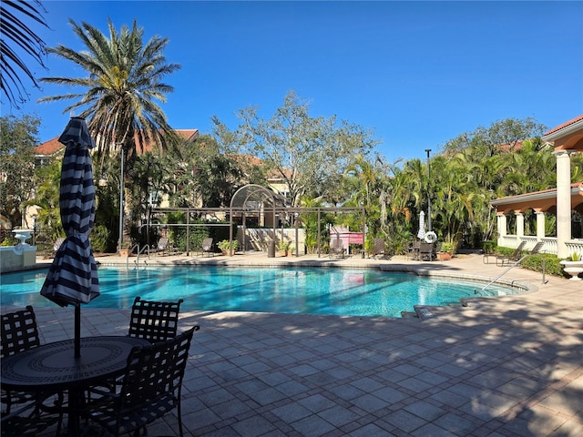 community pool featuring a patio area and fence