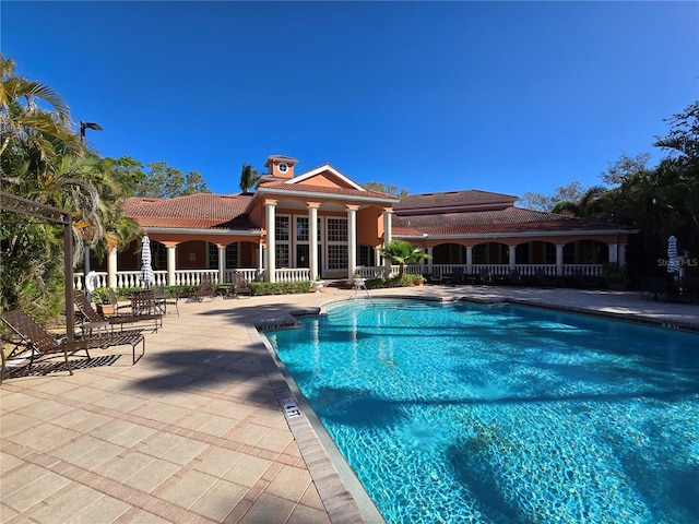 pool with a patio and fence