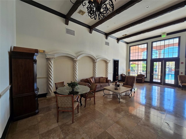 living area featuring beamed ceiling, a towering ceiling, and visible vents