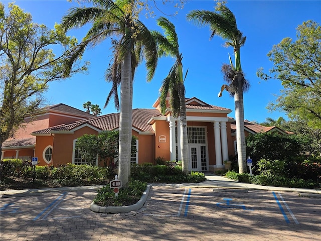 view of front of property with stucco siding, a tiled roof, and french doors