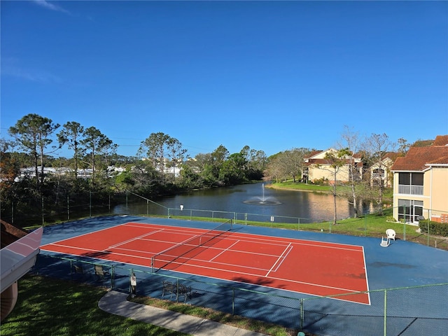 view of sport court featuring a water view and fence