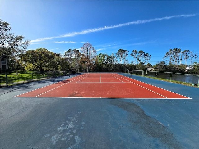 view of tennis court with community basketball court and fence