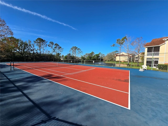 view of tennis court with community basketball court and fence