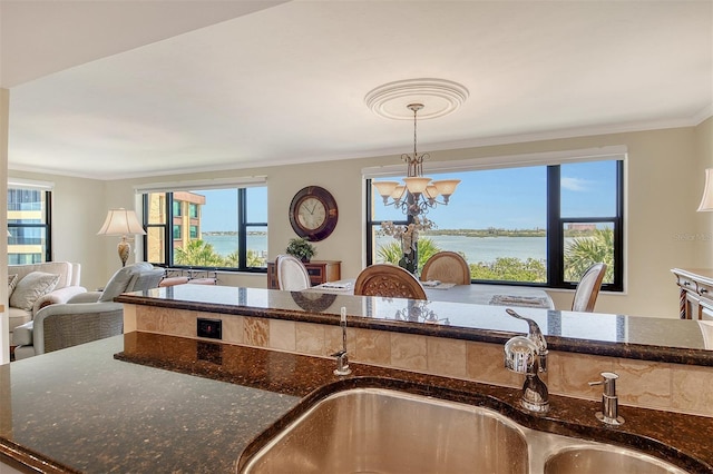 8779 Midnight Pass Rd Unit 406H, Sarasota, FL 34242 - kitchen with a sink, a chandelier, dark stone countertops, ornamental molding, and healthy amount of natural light