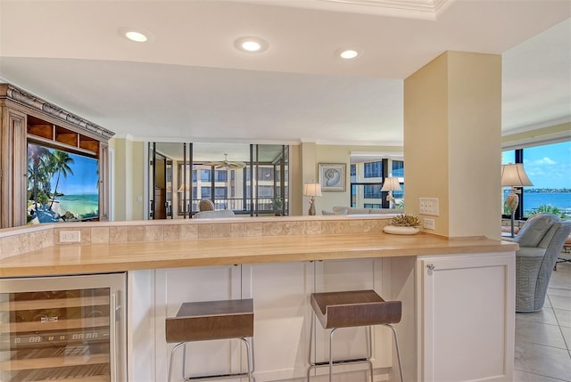 8779 Midnight Pass Rd Unit 406H, Sarasota, FL 34242 - kitchen featuring wine cooler, a breakfast bar area, light tile patterned floors, recessed lighting, and wooden counters