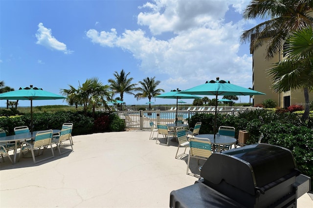 8779 Midnight Pass Rd Unit 406H, Sarasota, FL 34242 - view of patio / terrace featuring outdoor dining area, a community pool, and a grill