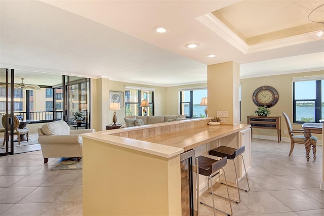 8779 Midnight Pass Rd Unit 406H, Sarasota, FL 34242 - kitchen featuring open floor plan, crown molding, healthy amount of natural light, a breakfast bar area, and light tile patterned floors