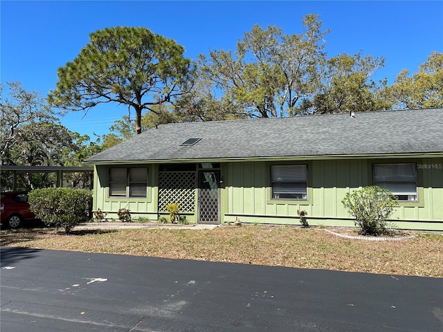 single story home with a shingled roof and board and batten siding