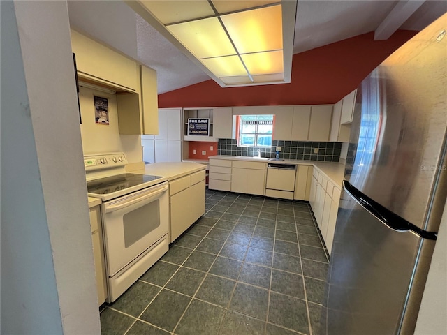 kitchen featuring white appliances, tasteful backsplash, dark tile patterned flooring, vaulted ceiling, and light countertops