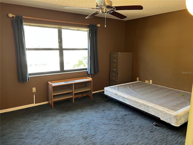 unfurnished bedroom featuring a textured ceiling, carpet, a ceiling fan, and baseboards