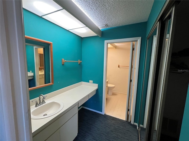 bathroom with visible vents, a textured ceiling, toilet, and vanity