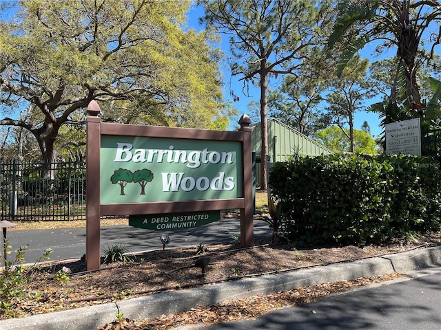 community sign with driveway and fence