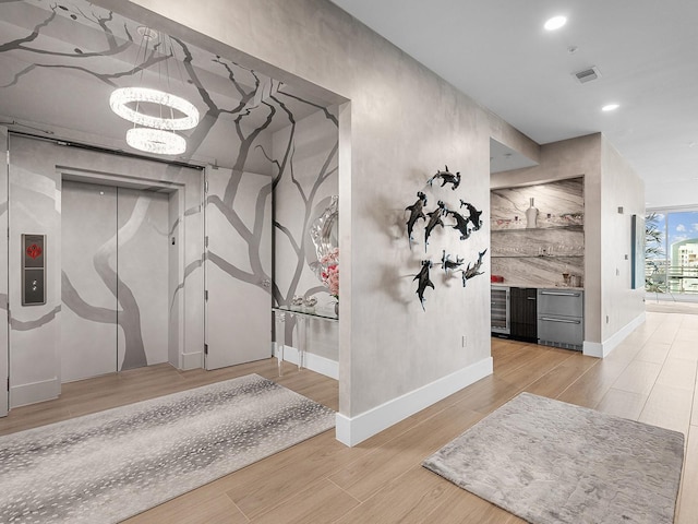 hall with recessed lighting, visible vents, light wood-style flooring, and baseboards