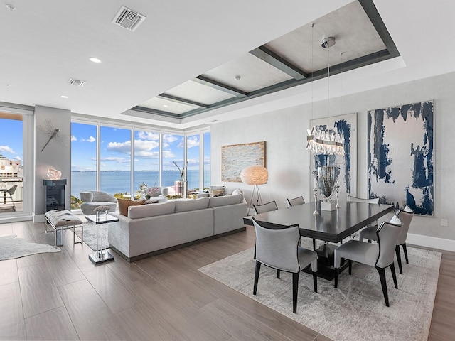 dining area featuring visible vents, baseboards, wood finished floors, and expansive windows