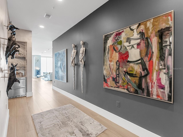 corridor with wood finished floors, recessed lighting, baseboards, and visible vents