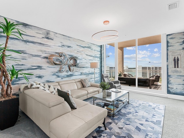 living room featuring visible vents, wallpapered walls, a wall of windows, and carpet floors