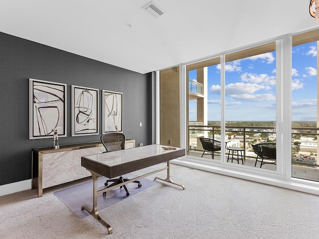 carpeted office featuring floor to ceiling windows, baseboards, and visible vents