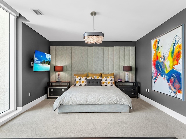 carpeted bedroom featuring baseboards and visible vents