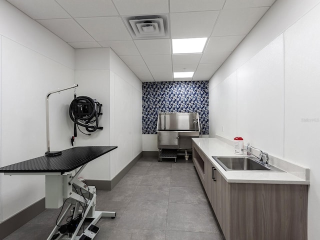 kitchen featuring visible vents, modern cabinets, a sink, light countertops, and a paneled ceiling